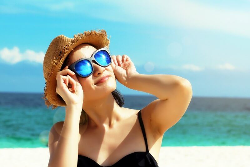 model smiling knowing she is looking after her skin in the summer