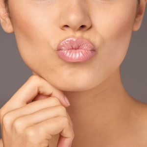 woman pursing her lips which could compromise her lip filler and would benefit from the 'lip flip' treatment 