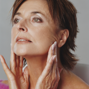 Woman examining her jawline in the mirror 
